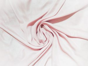 Weicher, rosa gefalteter Stoff – Symbol für Nähe, Intimität und das Verflochtensein zweier Menschen.